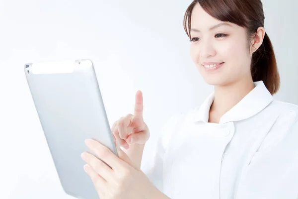 身穿白袍的漂亮的日本护士的工作室肖像 白种人背景的快乐医生 — 图库照片
