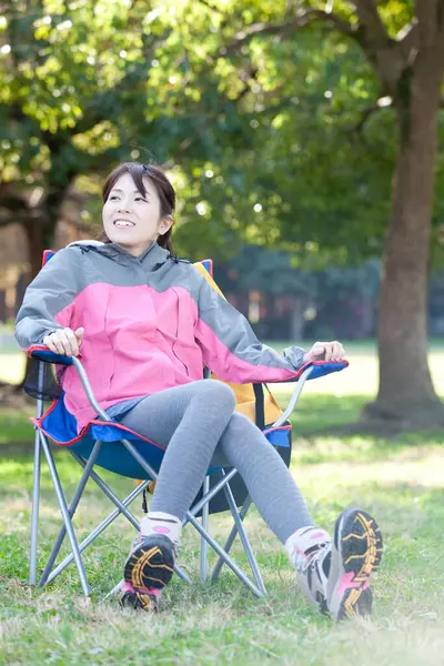 young asian woman relaxing in chair  in a forest