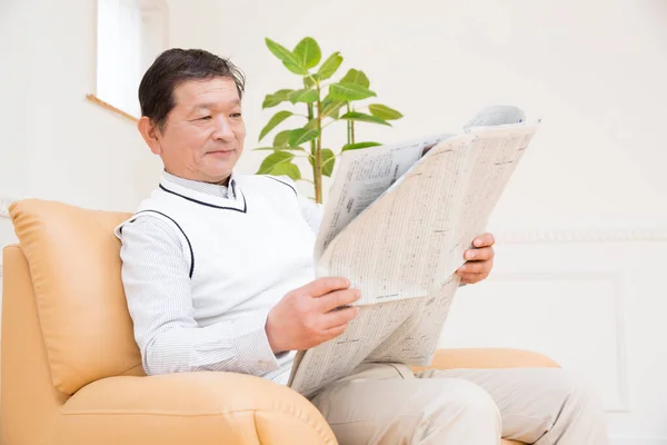 man reading newspaper at home