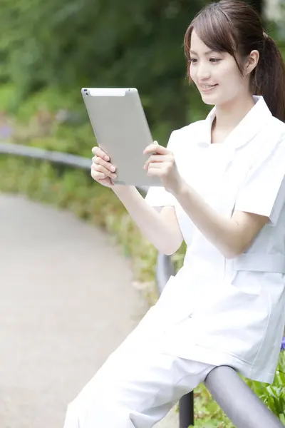 woman using a tablet computer in park