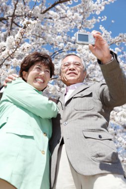 Mutlu Asyalı olgun çift selfie çekiyor.