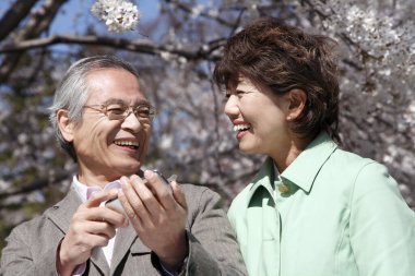 Mutlu Asyalı olgun çift selfie çekiyor.