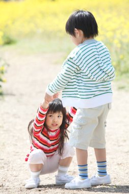 Çizgili giysilerle dışarıda oynayan çocuklar.