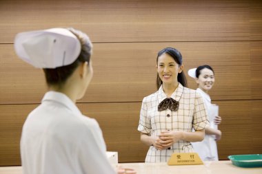 Hastanede idarecisi olan Asyalı kadın hemşireler. 