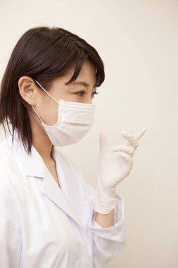 Tıbbi maskeli Asyalı kadın doktor.