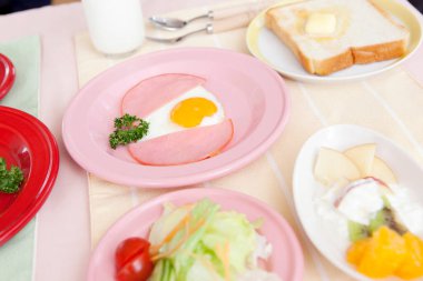 Kahvaltıda yumurta, sosis, salata. 