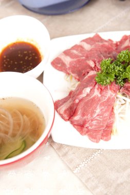 Sos ve garnitürlü çiğ et dilimleri.