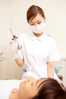 Genç bayan dişçiyi ziyaret ediyor.