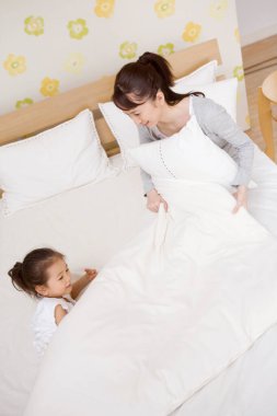 Anne ve tatlı küçük kızı yatakta yatıyor.