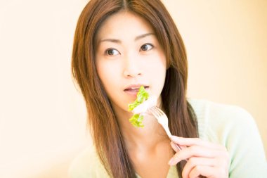 Restoranda yemek yiyen güzel bir Asyalı kadının portresi. 