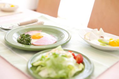 Kahvaltıda yumurta, sosis, salata. 