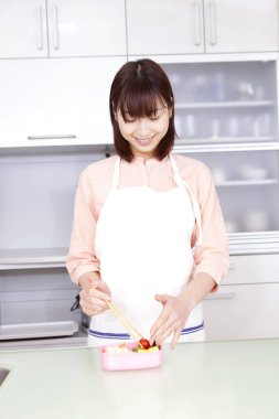 Mutfakta yemek yapan genç bir kadının portresi.