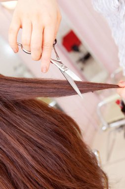 Asyalı kadın güzellik salonunda saç kesimi yapıyor.