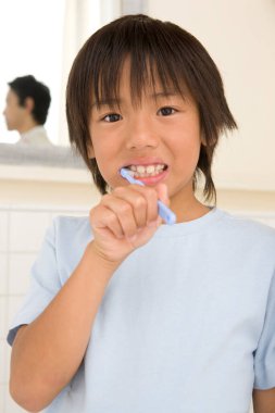 Elinde diş fırçası olan küçük bir çocuk.