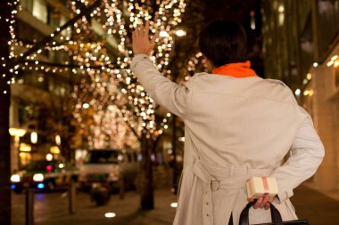 Asyalı genç adam gülümsüyor ve hediyesini tutuyor. 