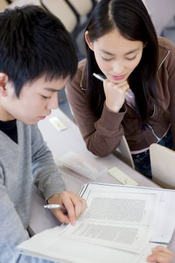 Asyalı öğrenciler kütüphanede okuyor