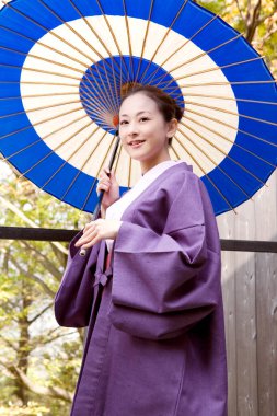 Geleneksel Japon kimonolu ve şemsiyeli iki genç kadın.