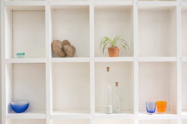 Raflarda farklı dekoratif eşyalar var.