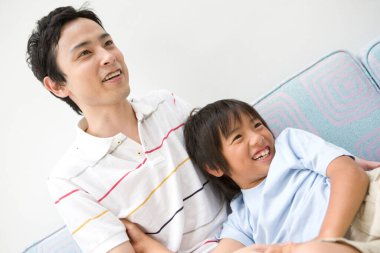 Baba ve oğul evde oynuyorlar.