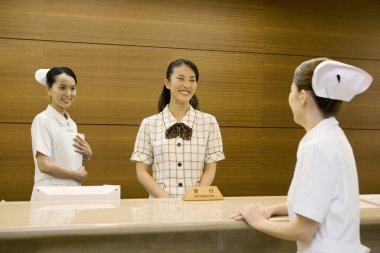 Hastanede idarecisi olan Asyalı kadın hemşireler. 