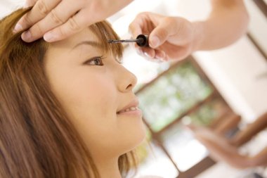 Makyaj yapan genç bayana yakın durun.