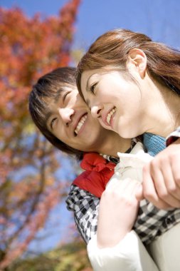 Sonbahar parkında gülümseyen bir çiftin portresi 