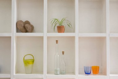 Raflarda farklı dekoratif eşyalar var.