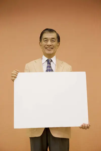 Portret Przystojnego Japońskiego Biznesmena Trzymającego Pusty Sztandar — Zdjęcie stockowe