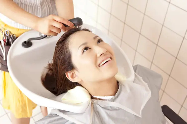 サロンで美容治療を受けている日本人女性 — ストック写真