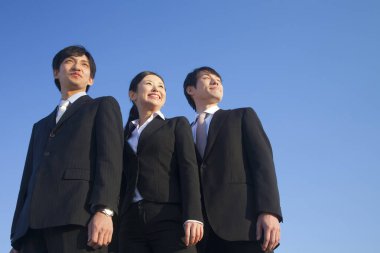 İş ekibi mavi gökyüzüne bakıyor.