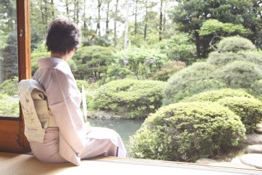 Kimonolu Japon kadın bir bahçeye hayran. 