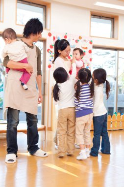 Anaokulunda öğretmenleri olan sevimli Asyalı çocuklar. 