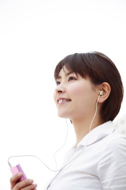 Müzik açık havada için dinleme genç Asyalı kadın