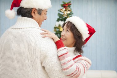 Asyalı yaşlı çift Noel 'de evde dans ediyor. 