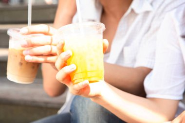 Kafede soğuk içecekler içen genç çift, yakın plan.