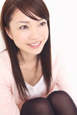 Güzel genç Asyalı kadın stüdyoda yerde oturuyor. 