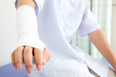 Hastanedeki kazadan sonra elinde bandaj olan adam.