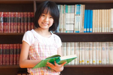 Okul kütüphanesindeki mutlu Japon çocuk portresi