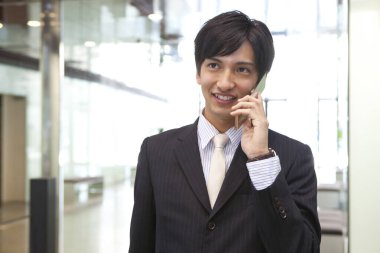 Takım elbiseli bir adam cep telefonuyla konuşuyor.