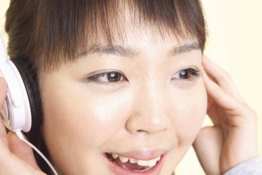 Stüdyoda kulaklıklı Asyalı kadın. 