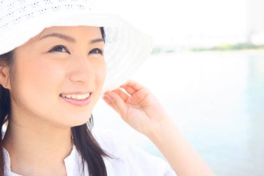 Beyaz şapkalı ve gülümseyen bir kadın.