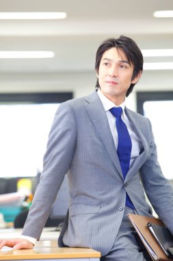 Masada oturan takım elbiseli bir adam.