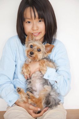 Yorkshire Terrier köpeği tutan Japon kızın portresi