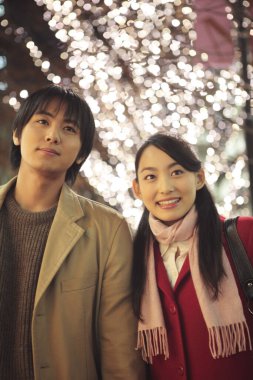 Genç Asyalı çift dışarıda poz veriyor.