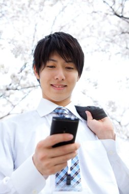 Parkta cep telefonu olan bir işadamı. 