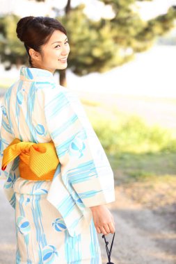 Kimonolu bir kadın yolda yürüyor.