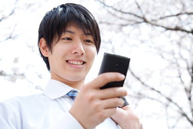 Parkta cep telefonu olan genç bir işadamı 