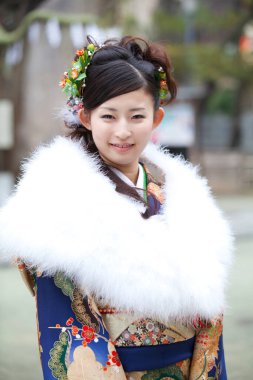 Beyaz kürklü geleneksel kimono giyen gülümseyen Japon kadın.