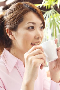 Elinde kahve tutan bir kadın.