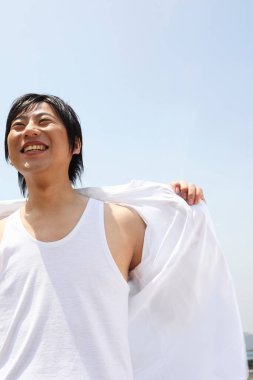 Omuzlarının üzerinde beyaz gömlekli bir adam.